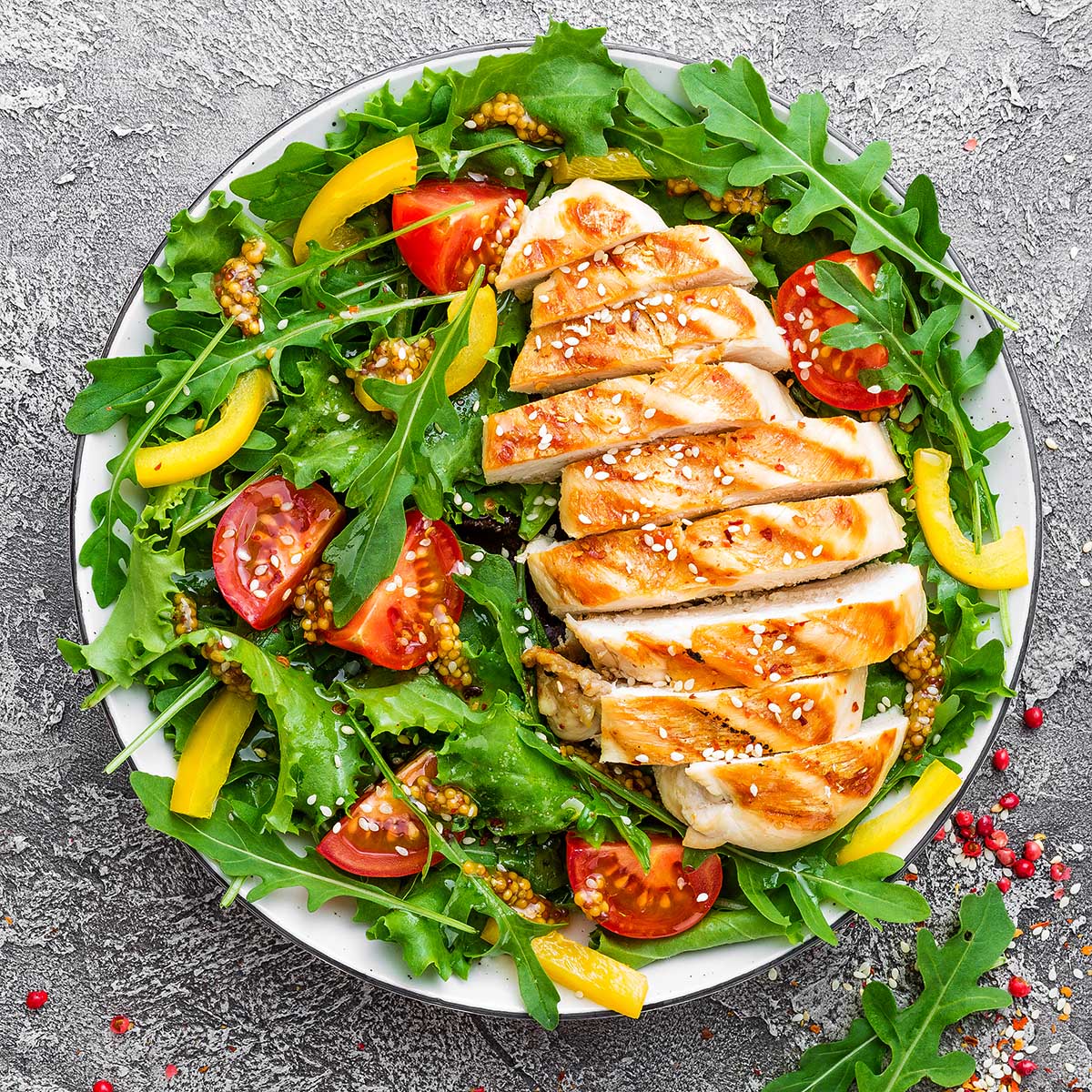 Chicken salad. Meat salad with fresh tomato, sweet pepper, arugula and grilled chicken breast. Chicken fillet with fresh vegetable salad Food, Restaurant, Bar & Lounge Photography - Website Design & Social Media Marketing - Palm Island Creative